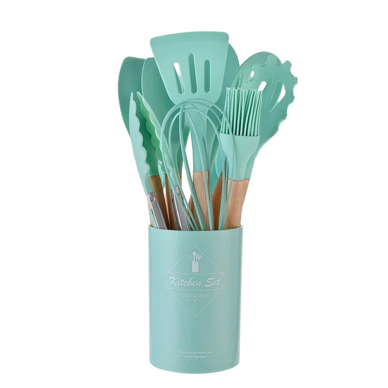 12-piece non-stick silicone kitchen utensils set with wooden handles, including spatula and egg beaters, in a mint container.