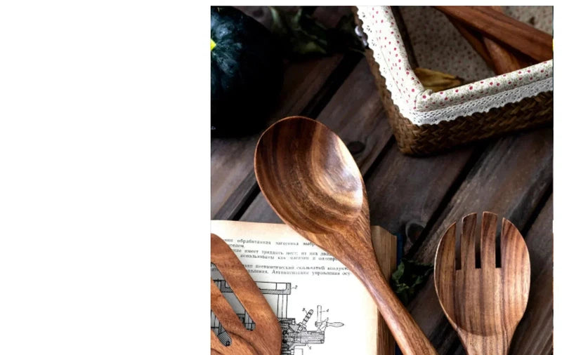 Wooden kitchen utensils set with soup spoon and spatula on a table.