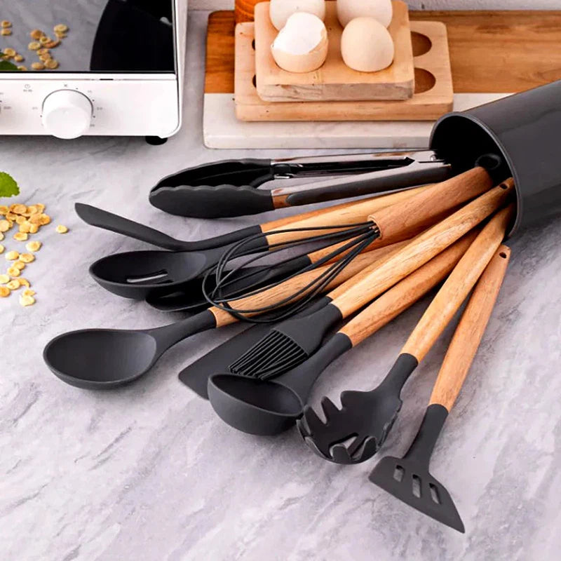 12-piece silicone kitchen utensils set with wooden handles and storage bucket on countertop.