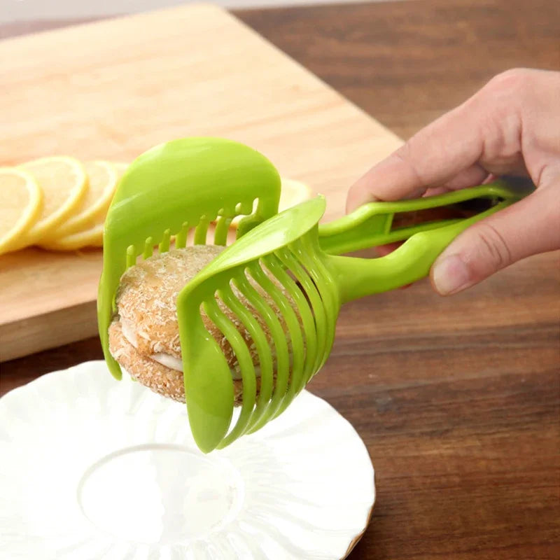 Stainless steel handheld fruit slicer for oranges and lemons, tomato cutting tool in use.