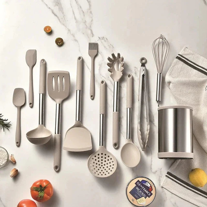 12-piece silicone kitchen utensil set with stainless steel handles and rotating storage bucket on marble countertop.