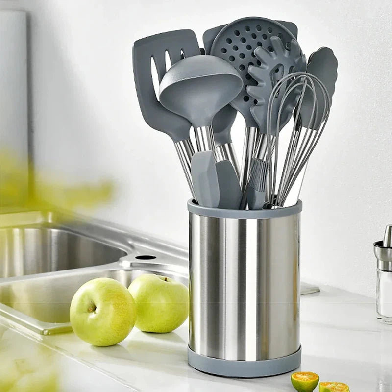 12-piece silicone kitchenware set with spatula, soup spoon, and eggbeater in a stainless steel rotating storage bucket.